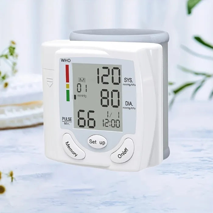 Blood pressure tester with digital display showing systolic, diastolic, and pulse readings on table.