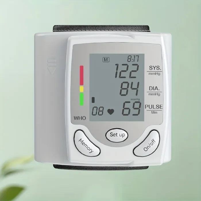 Blood pressure tester with large LCD screen and color-coded indicators against a green background.
