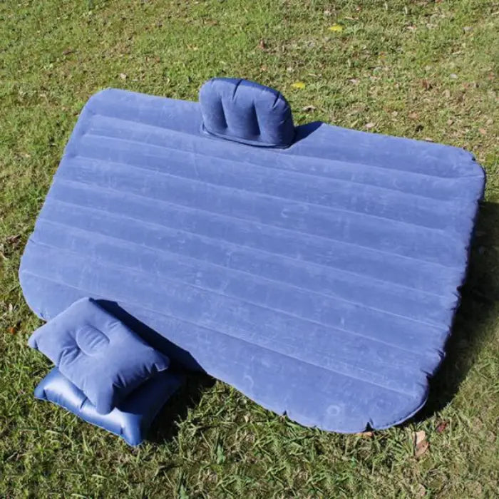 Blue car air mattress with dual pillows shown outdoors demonstrating versatile camping and car use