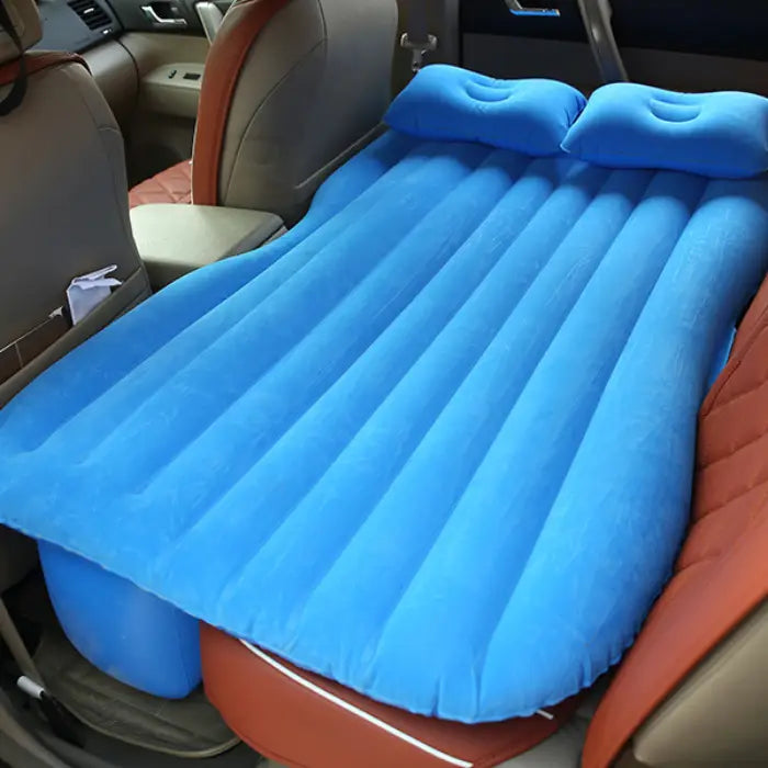 Car air mattress placed in back seat creating flat sleeping surface with built-in comfort pillows