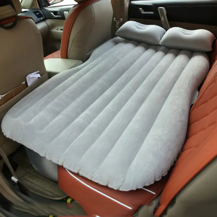 car air mattress lying across a car back seat for comfortable support on road trips