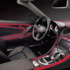 Red LED strips highlighting car interior dashboard and door lines in a luxury black vehicle