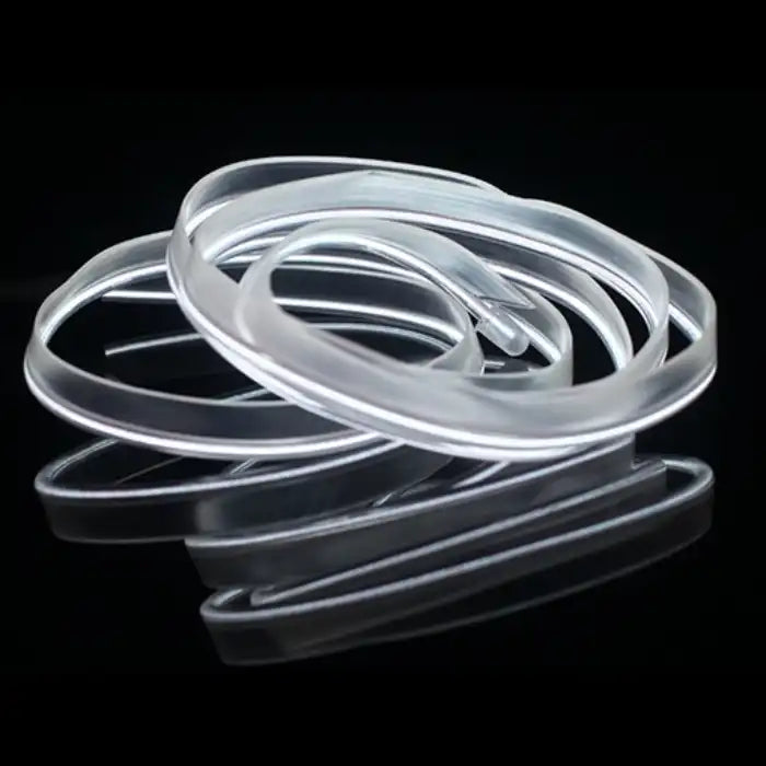 White glowing LED strip coiled for car interior lighting, shown on reflective black surface