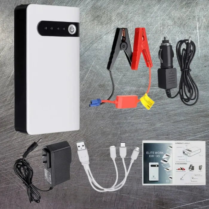 Emergency car battery jump starter kit and tools laid out on brushed metal surface background.