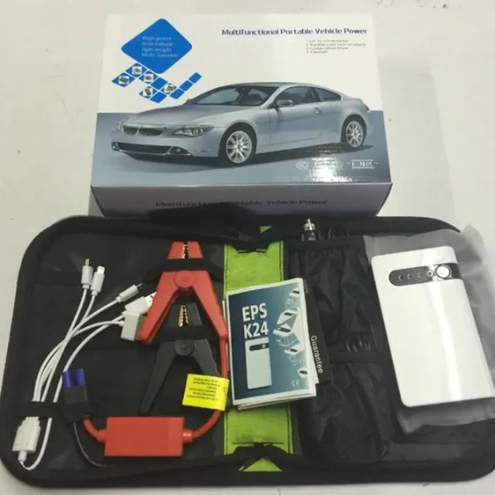 Emergency car battery jump starter kit shown with box, clamps, cables, and instruction manual.