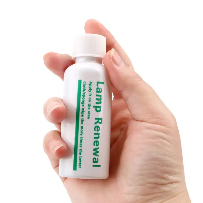 Headlight Repair cleaner 50ml bottle held in hand for easy application on car headlights.