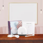 Infant nail clipper kit with box, USB cable, manual, and tool displayed on table.