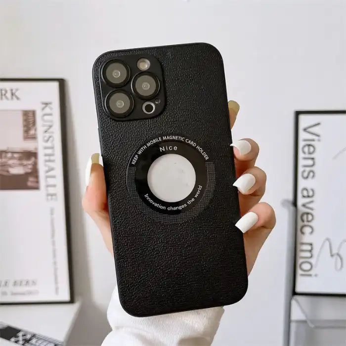 iPhone protective case in black leather texture held against white interior background