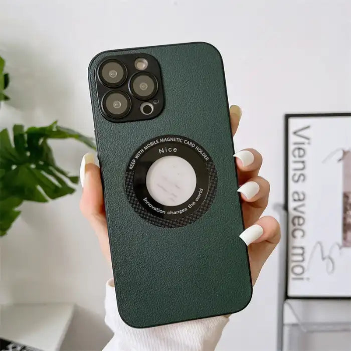 Green leather iPhone protective case held by hand with plant decor in background