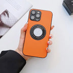 Orange leather iPhone protective case with circular magnetic holder, held by hand