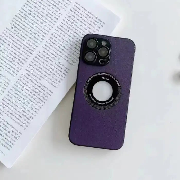 iPhone protective case in dark purple leather design lying on a book