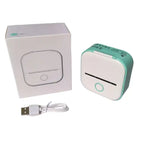 Mini Thermal Printer shown with packaging box and USB charging cable on white desk