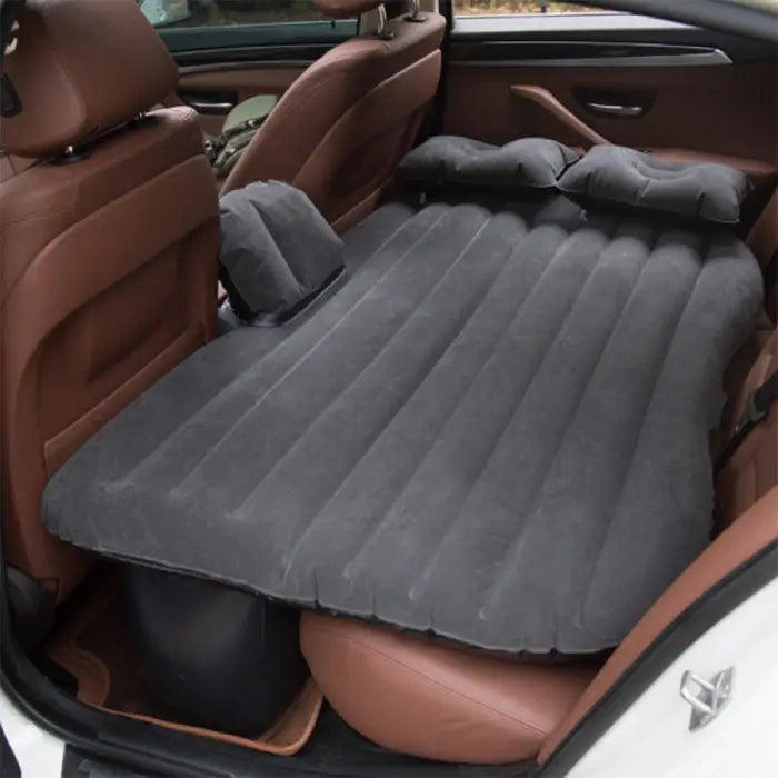 car air mattress with pillows installed in vehicle backseat for camping and travel comfort