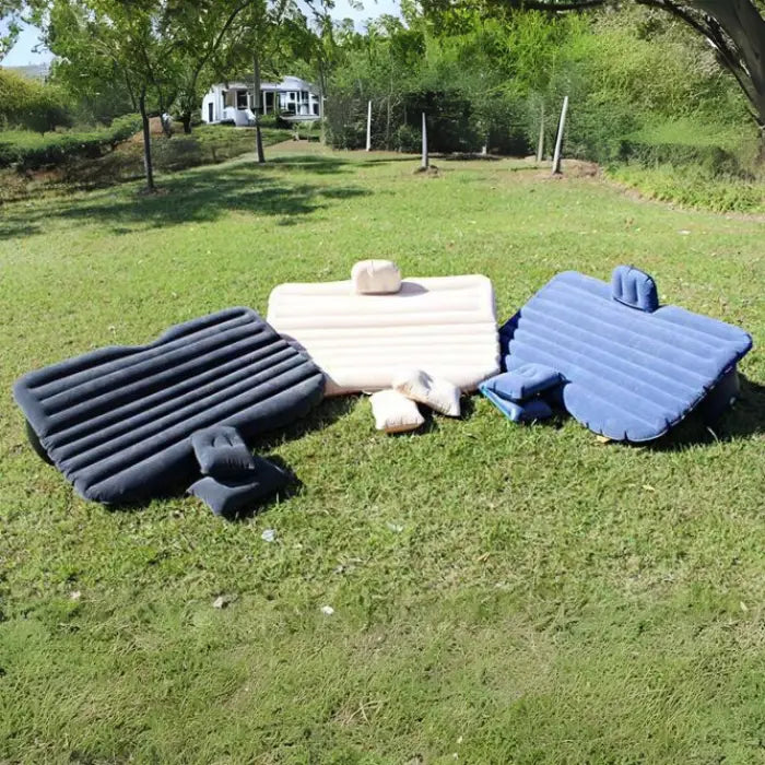 Portable car air mattresses in black, beige and blue colors with headrests and side supports, displayed outdoors showing comfort features