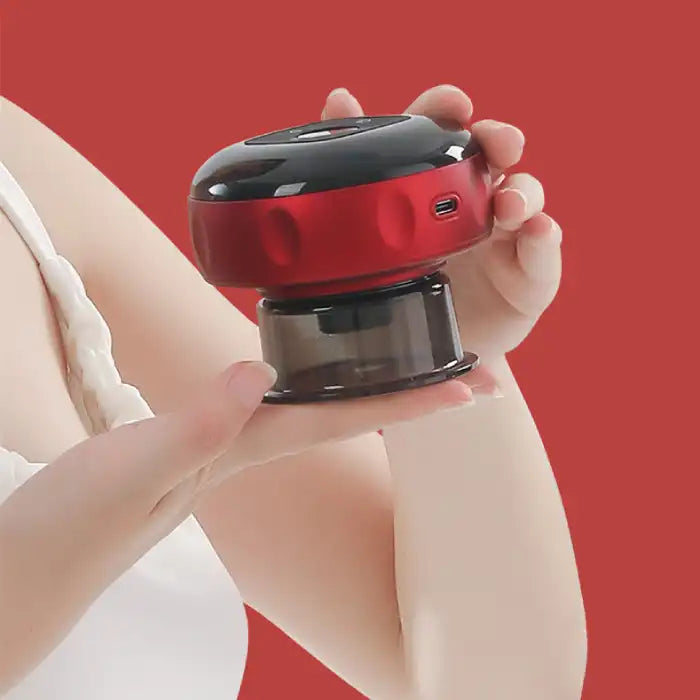 Person holding compact red vacuum massager in hand with black top and USB charging port