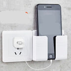 Wall mount phone holder securely holding black phone while charging at a wall power outlet.