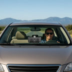 Wireless CarPlay Display installed in a vehicle with driver using the system on a clear road.